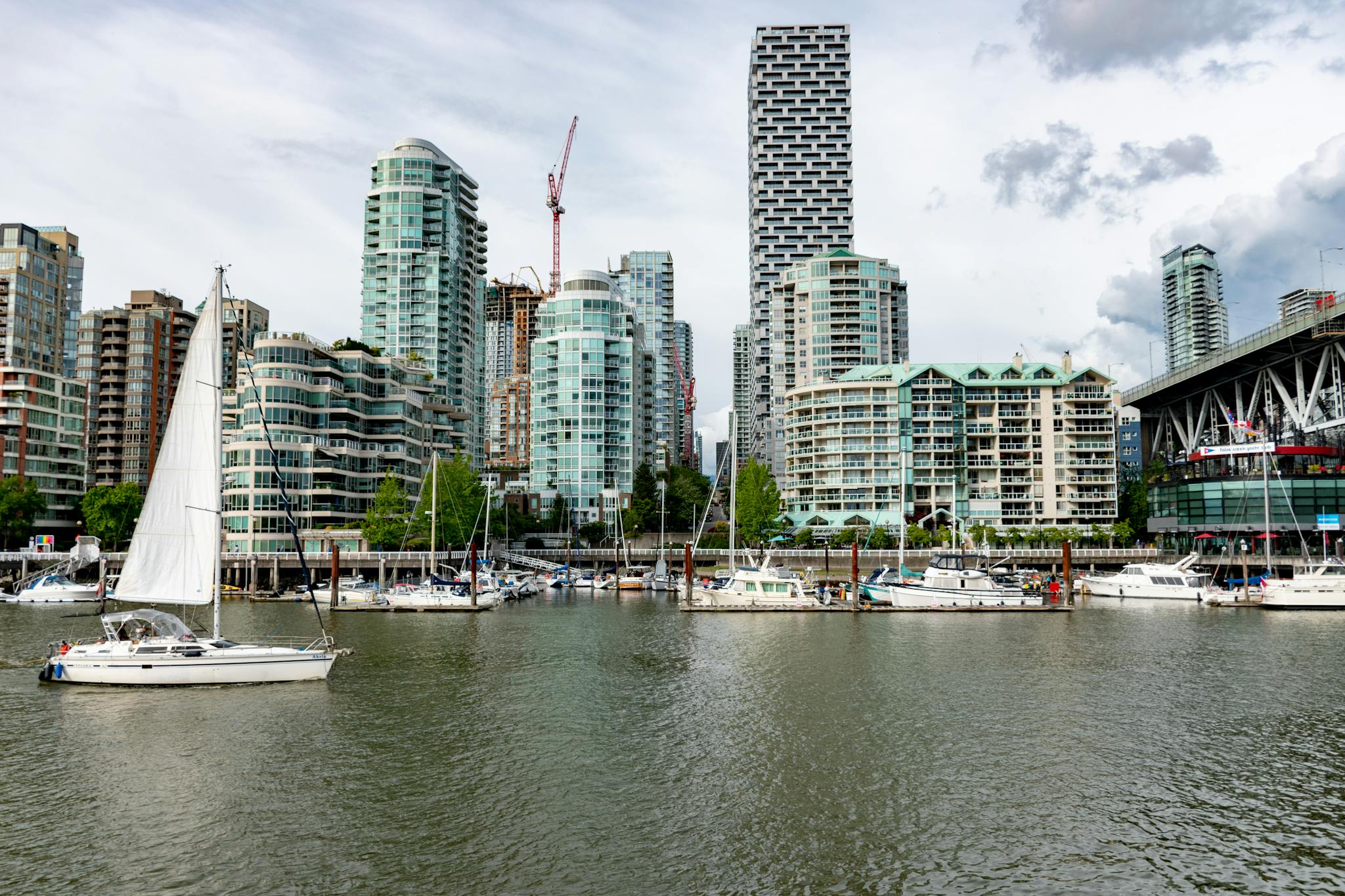Modern skyline of Vancouver with sailboats and yachts docked at the waterfront marina.