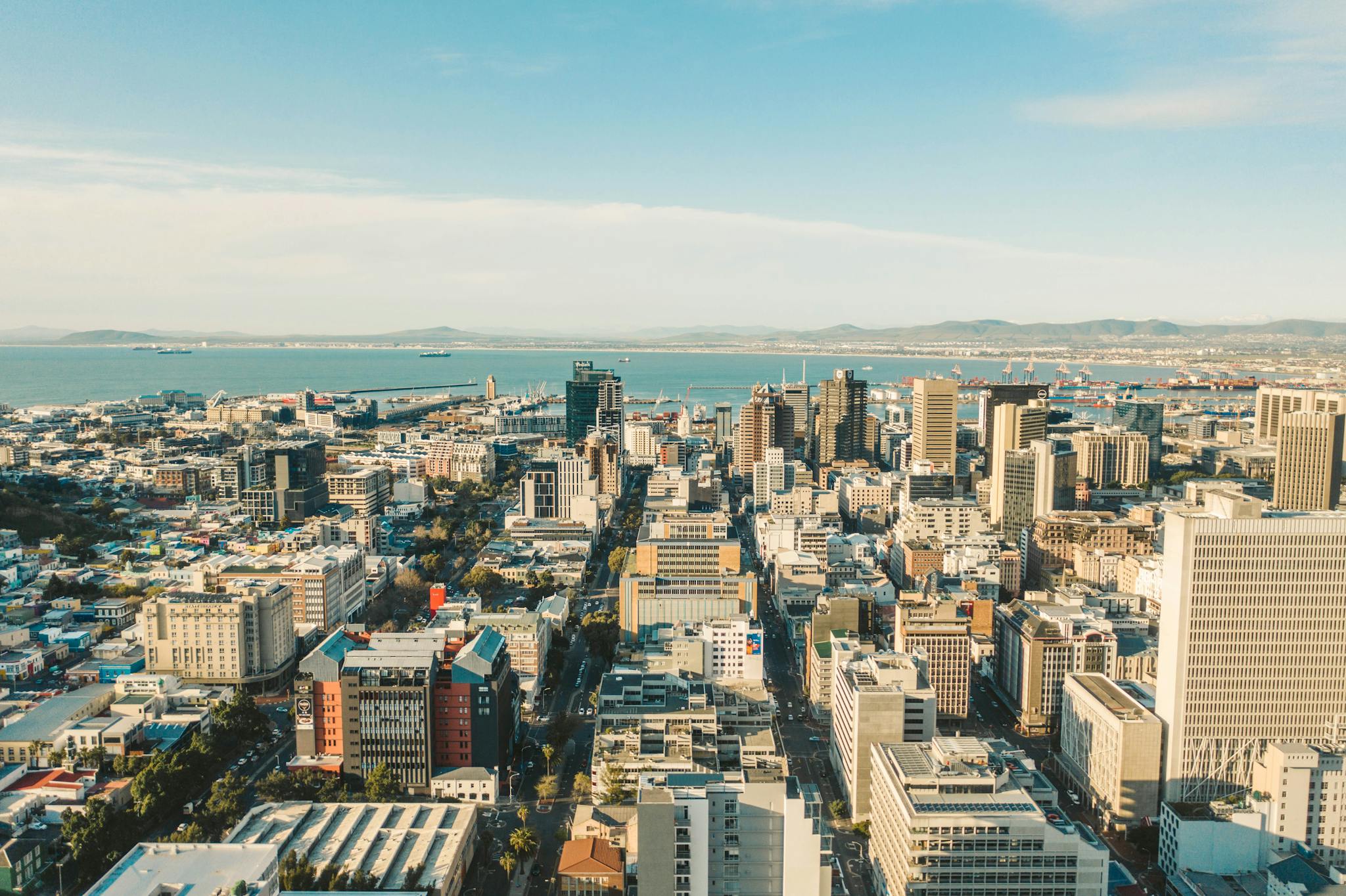 Stunning aerial view of Cape Town cityscape with its skyline and ocean in the background on a bright day.